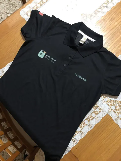 Polo negra con logo institucional y nombre